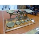 A VICTORIAN POSTAL SCALE WITH WEIGHTS ON AN OAK PLINTH BASE.