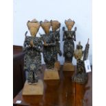 A GROUP OF FIVE SOUTH EAST ASIAN CARVED FIGURES CONSTRUCTED WITH COINS OR MEDALLIONS, FOUR