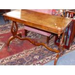 A VICTORIAN WALNUT CENTRE TABLE ON SHAPED END SUPPORTS AND BRASS CASTORS. W.104 x H.68 x D.50cms.