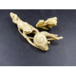 A JAPANESE IVORY CARVING OF A TOAD REACHING TOWARDS A SNAIL. W.9.5cms AND AN IVORY GROUP OF TWO