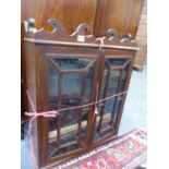 AN ANTIQUE OAK WALL CABINET WITH GLAZED DOORS ENCLOSING SHELVES.
