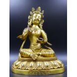 AN ORIENTAL GILT BRONZE FIGURE OF A SEATED DEITY ON A LOTUS BASE, CHARACTER MARKS TO BASE. H.22cms.
