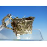 AN ORIENTAL WHITE METAL CREAM JUG IN THE ART NOUVEAU MANNER WITH RELIEF LEAF AND FOLIATE DECORATION,