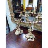 A PAIR OF GILT METAL ROCOCO STYLE TWIN LIGHT CANDELABRA WITH SCROLL ARMS AND PUTTI SUPPORTS. H.
