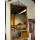 A VICTORIAN GILTWOOD AND GESSO FRAMED PIER MIRROR WITH URN SURMOUNT AND STILL LEAF MOULDED FRAME.