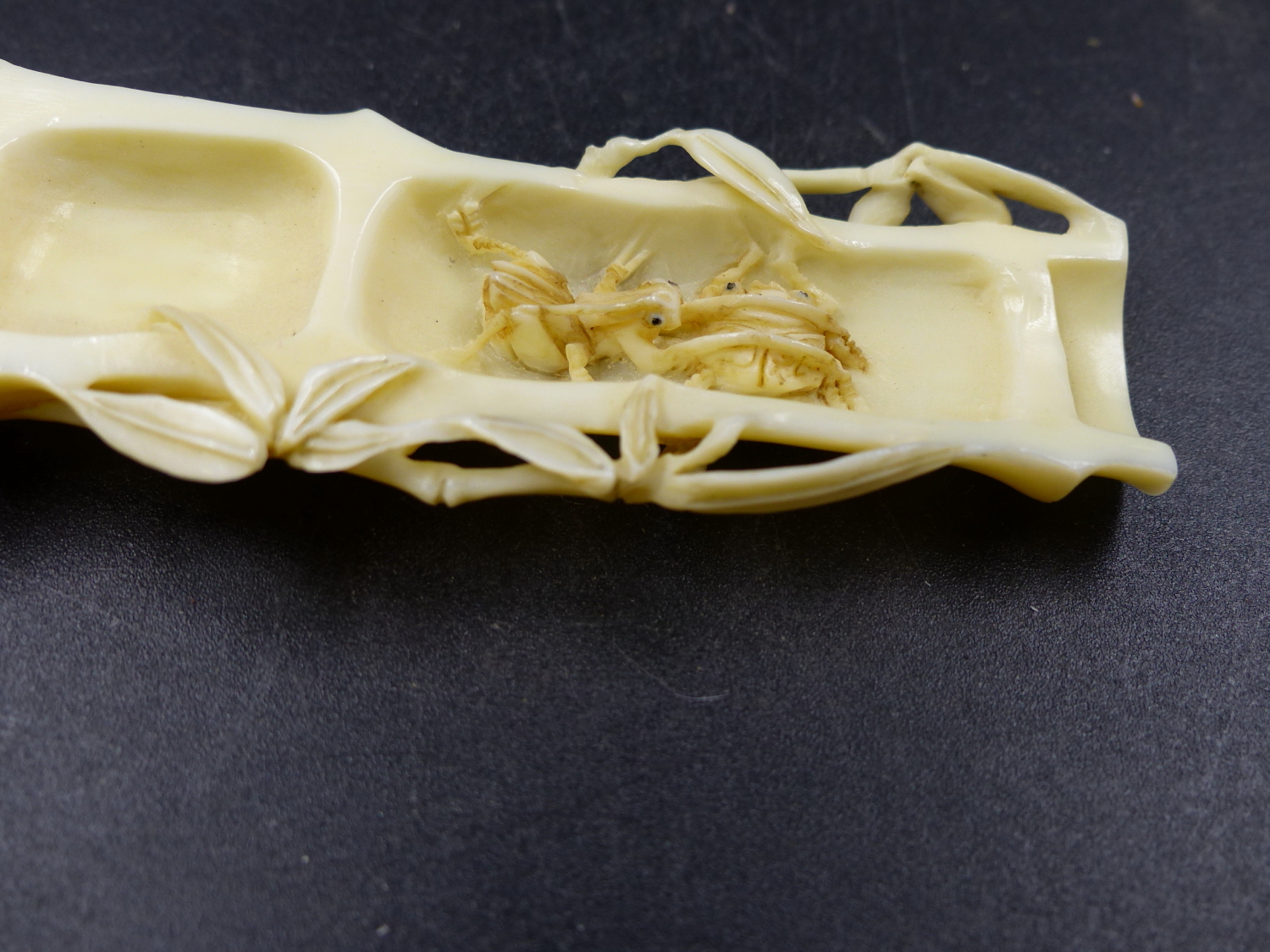 A JAPANESE MARINE IVORY OKIMONO CARVED AS A SPLIT SECTION OF BAMBOO CONTAINING A CONFRONTATION OF - Image 3 of 6
