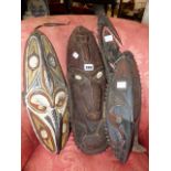 THREE CARVED WOOD TRIBAL MASKS, TWO WITH POLYCHROME DECORATION TOGETHER WITH A CARVED TRIBAL FIGURE.