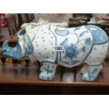 A DAVID SHARP RYE POTTERY BLUE AND WHITE POTTERY RHINOCEROS PAINTED WITH FLOWERS. W.42cms.