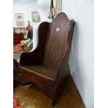 AN ANTIQUE OAK RUSTIC CHILD'S ROCKING CHAIR.