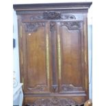 A LARGE FRENCH PROVINCIAL CARVED OAK TWO DOOR ARMOIRE. W.144 x H.215cms.