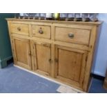 A VICTORIAN PINE SMALL KITCHEN DRESSER WITH THREE DRAWERS OVER THREE CUPBOARD DOORS. W.133 x H.82