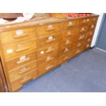 A LARGE MID CENTURY BANK OF TWENTY FIVE OAK DRAWERS.