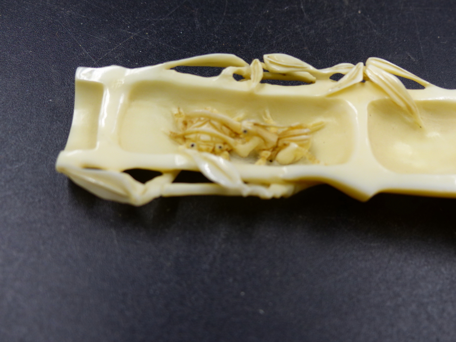 A JAPANESE MARINE IVORY OKIMONO CARVED AS A SPLIT SECTION OF BAMBOO CONTAINING A CONFRONTATION OF - Image 4 of 6