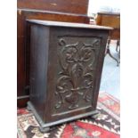 A SMALL OAK TABLE CABINET WITH CARVED DOOR ON BUN FEET. W.40 x H.59 x D.29cms.