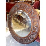 A CIRCULAR CARVED OAK FRAMED CONVEX WALL MIRROR. Dia.76cms.