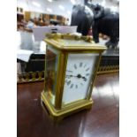AN EARLY 20th.C.BRASS CASED CARRIAGE CLOCK WITH WHITE ENAMEL DIAL AND SIGNED MOVEMENT.