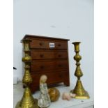 A PAIR OF BRASS CANDLESTICKS. H.24cms, A MAHOGANY MINIATURE CHEST OF FOUR DRAWERS. H.29cms AND STONE