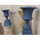 A PAIR OF ANTIQUE AND LATER PAINTED CAST IRON FLUTED GARDEN URNS ON SQUARE PLINTH BASES. H.68cms.