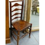 AN ANTIQUE COUNTRY LADDERBACK CHAIR WITH PLANK SEAT.