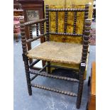 AN ANTIQUE COUNTRY BOBBIN TURNED ARMCHAIR WITH RUSH SEAT.