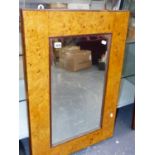 A BURR WALNUT FRAMED WALL MIRROR. 59 x 84cms.