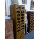 A TALL HABERDASHERY CABINET OF SIXTEEN GLAZED FRONT DRAWERS OVER FOUR DEEP ENCLOSED DRAWERS. W.62