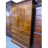 AN EDWARDIAN MAHOGANY AND INLAID WARDROBE WITH HANGING SPACE OVER TWO LONG DRAWERS ON A PLINTH BASE.