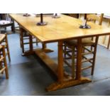 AN ARTS AND CRAFTS GOLDEN OAK HEAL'S TILDEN REFECTORY TABLE ON FOUR GUN BARREL TURNED SUPPORTS.