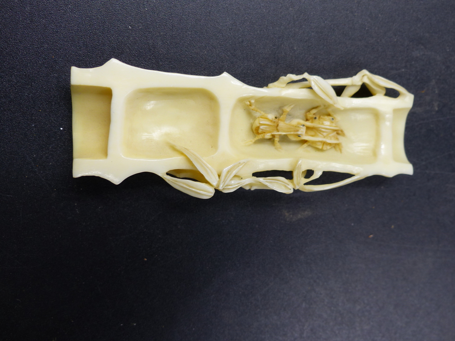 A JAPANESE MARINE IVORY OKIMONO CARVED AS A SPLIT SECTION OF BAMBOO CONTAINING A CONFRONTATION OF - Image 2 of 6