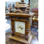 A LATE VICTORIAN WALNUT CASED MANTLE CLOCK WITH PAINTED AND GILT DIAL, GONG STRIKE MOVEMENT.