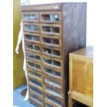 A VINTAGE HABERDASHERY CHEST OF TWENTY GLASS FRONTED DRAWERS. W.81 x H.165 x D.50cms.