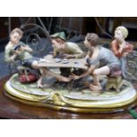 A LARGE CAPO DI MONTE STYLE PARIAN FIGURE GROUP OF BOYS PLAYING CARDS AROUND A RUSTIC TABLE.