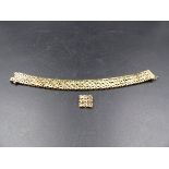 A 9ct GOLD TEXTURED WOVEN DESIGN BRACELET COMPLETE WITH A SECTION OF EXTRA LINKS. CURRENT LENGTH