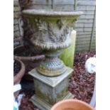 A COMPOSITE STONE CLASSICAL URN AND ASSOCIATED PLINTH BASE.