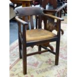 AN ARTS AND CRAFTS OAK DESK ARMCHAIR WITH LEATHER SEAT PAD.