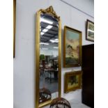 A VICTORIAN STYLE GILT FRAMED TALL PIER MIRROR WITH MOULDED CREST. 178 x 56cms.