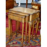A GEORGIAN STYLE WALNUT NEST OF TABLES WITH GILT HIGHLIGHTED CARVED DECORATION ON BALL AND CLAW