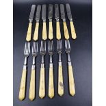A SET OF TWELVE DESSERT KNIVES AND FORKS, THE HANDLES AND BLADES DECORATED IN THE AESTHETIC STYLE.