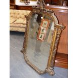 A 19th.C.CARVED GILTWOOD FRAMED WALL MIRROR WITH SHELL CREST AND VINE ENTWINED FLANKING COLUMNS.