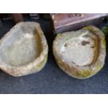 TWO ANTIQUE SMALL HORSESHOE FORM CARVED STONE PUMP TROUGHS.