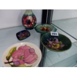 FOUR MOORCROFT DISHES AND A SMALL VASE., ONE DISH WITH PAPER LABEL.
