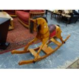 A LARGE CARVED PINE ROCKING HORSE.