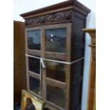 A CARVED OAK GLAZED CABINET.