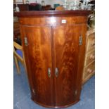 A GEO.III.MAHOGANY AND INLAID BOW FRONT CORNER CABINET.