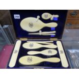 A CASED IVORY BACKED DRESSING TABLE SET.