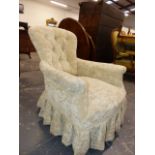 A VICTORIAN CREAM VELVET UPHOLSTERED BUTTON BACKED ARMCHAIR WITH THE TURNED FRONT LEGS ON WHITE