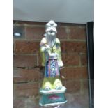 A CHINESE PORCELAIN FIGURE OF SHOULAO STANDING WEARING A YELLOW GROUND ROBE AND HOLDING A PEACH. H.