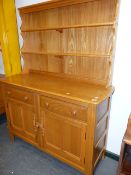 AN ERCOL PALE ELM DRESSER WITH OPEN PLATE RACK. 123 x 48cms.