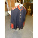 A VINTAGE BANDSMAN'S BLACK TUNIC WITH CRIMSON COLLAR AND CUFFS TOGETHER WITH A VINTAGE DISPLAY