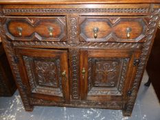 AN ANTIQUE AND LATER OAK DEUDDARN, THE CORNICE WITH PENDANT ENDS OVERHANGING TWO FOLIAGE CARVED